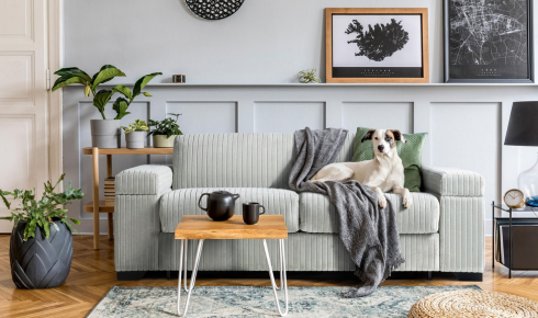 How can repeating one material, like wood or metal, in different rooms make the home feel more unified