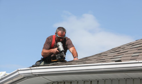 How can spotting tiny bits of roofing material in gutters hint at early wear