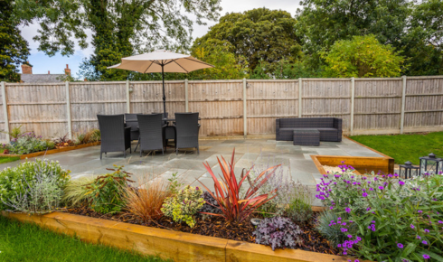 Why might using different heights of plants make a small garden look more layered